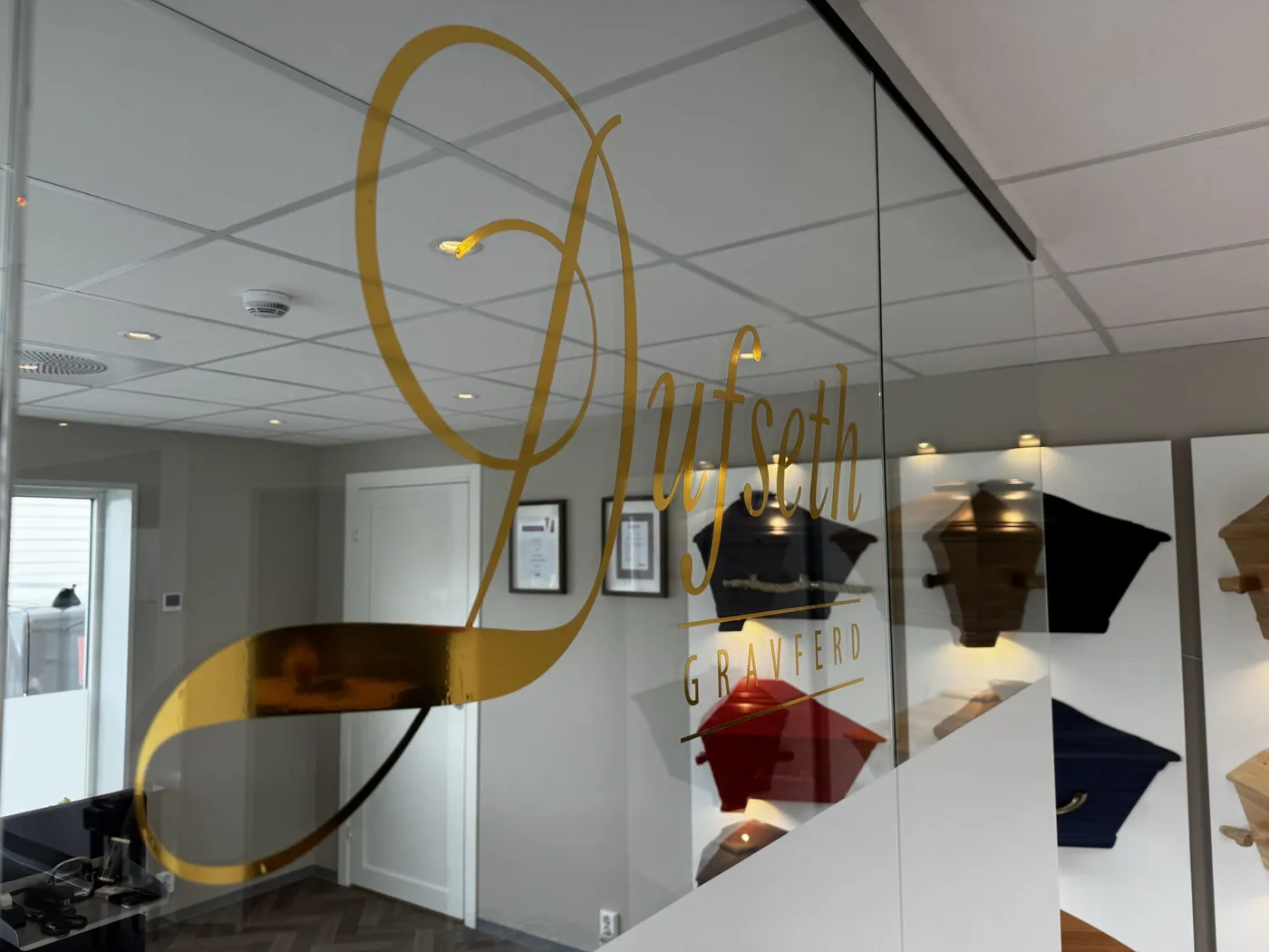Resepsjonen hos Dufseth Gravferd med logoen i gull på glassveggen